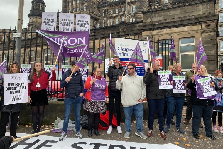 30 travailleurs faisant campagne sur le salaire du NHS à Glasgow avec des drapeaux et des bannières violets Unison 
